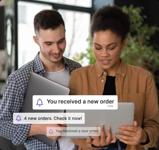 Two Shopify brand owners reviewing new orders on a laptop